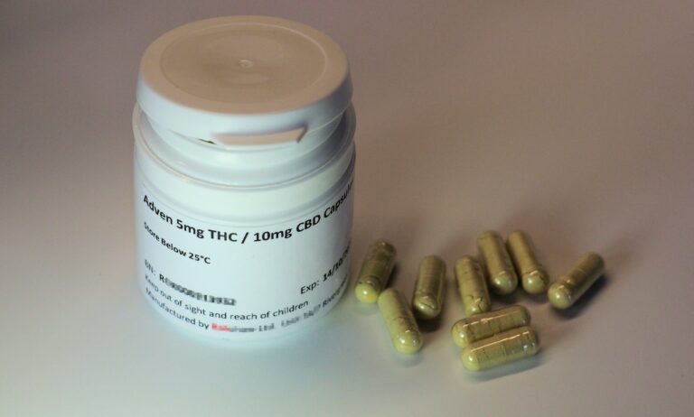 white plastic bottle with brown tablets of THC