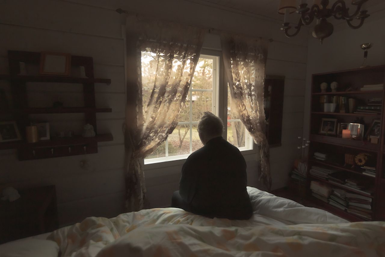 Lonely senior man looking out of window