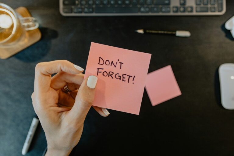 a person holding a note that says don't forget